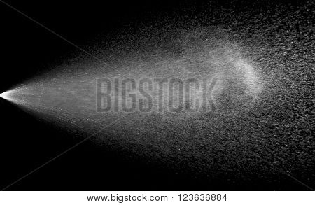 Spraying of water from the sprinkler. Isolate on black.