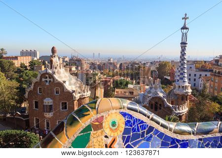 Barcelona, Spain - November 10, 2015: Park Guell entrance buildings and mosaic bench. The Park Guell is a public park system composed of gardens and architectonic elements. The park was built between 1900 and 1914 and was designed by Antoni Gaudi.