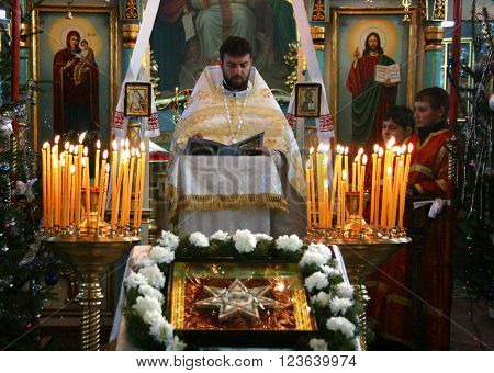VOYUTYN UKRAINE - JANUARY 08: Orthodox priest and little sexton during Christmas service in Voyutyn on January 08 2009.