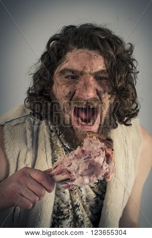 Silly hungry cave man eating ham on the bone