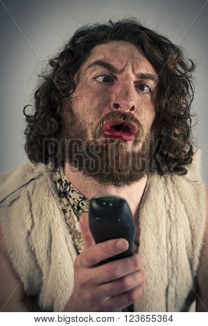 Silly grunting cave man confused by television remote