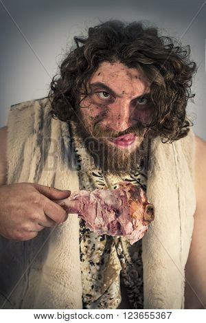 Silly hungry cave man eating ham on the bone