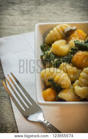 Vegetarian gnocchi dish with squash kale and mushrooms