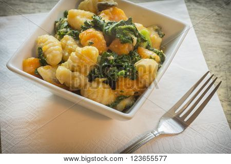 Vegetarian gnocchi dish with squash kale and mushrooms