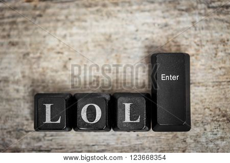 keys on a wooden table with the word lol concept laughing