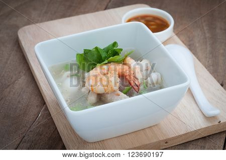 Dining table with Thai  food with Ekaehla and sauce on wooden floor.