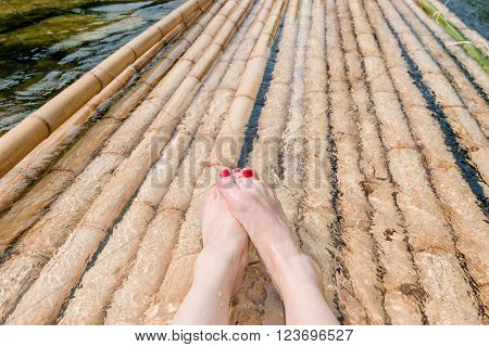 legs on bamboo raft located in Phang-Hga Thailand.