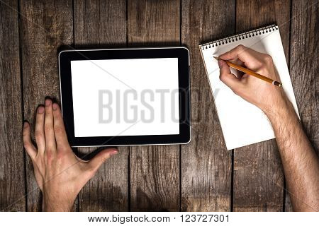 Male Hands Using Computer Tablet And Draw A Pancil In Notebook On Wooden Table
