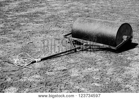 Old Rusty Iron Barrel For Maintenance Of Neglect Tennis Court. Old Dry Red Crushed Bricks Surface On