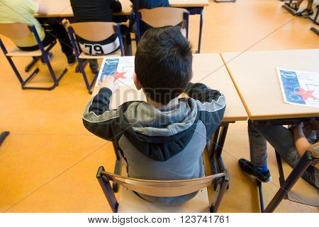 ENSCHEDE NETHERLANDS - MAR 22 2016: Child of 11 years old sitting behind his desk in a school class.
