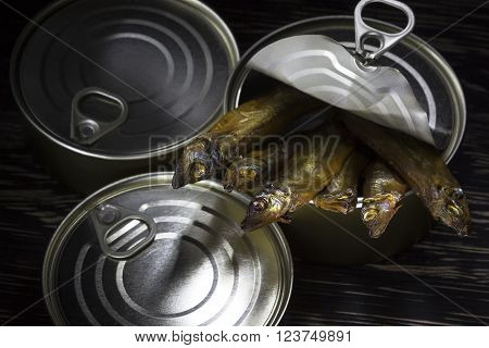 Close-up of Tinned capelin fish on dark wooden background