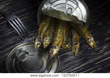 Close-up of Tinned capelin fish on dark wooden background