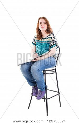 Beautiful smiling redhead plus size wreckled model with folder and ballpoint pen sitting on the bar chair. Isolated on a white background.