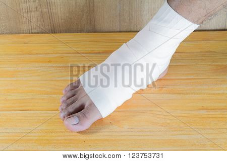 male is wrapping his Foot injury with bandage.