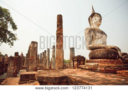SUKHOTHAI, THAILAND - FEB 16: Ruined temple Wat Maha That with great stone Buddha statues at Sukhothai historical park on February 16, 2016 in Thailand. Sukhothai historical park is a UNESCO World Heritage Site.