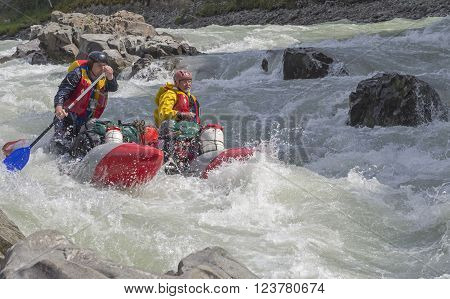 CHUYA RIVER RUSSIA - AUGUST 7 2014: Extreme rafting. Sports catamaran in a difficult rapids. River Chuya Altai. Tourists call this rapids as "Horizon"