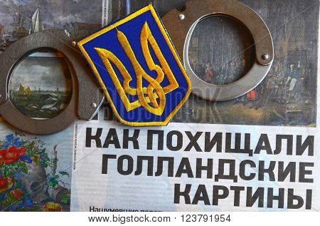 Kiev,Ukraine.FEB 20.ILLUSTRATIVE EDITORIAL.Chevron Ukrainian nazionalist battalion.Background - newspaper about West Frisian Museum stolen art . February 20,2016 in Kiev, Ukraine
