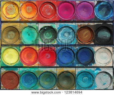 Closeup of messy, used water-color paintbox