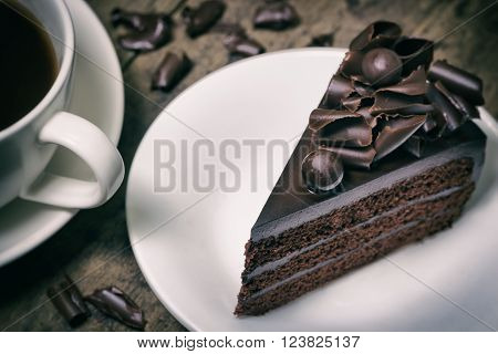 chocolate cake topping with chocolate curl on wood background vintage toning
** Note: Shallow depth of field