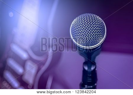 selective focus microphone and blur electric guitar background and flare light.
