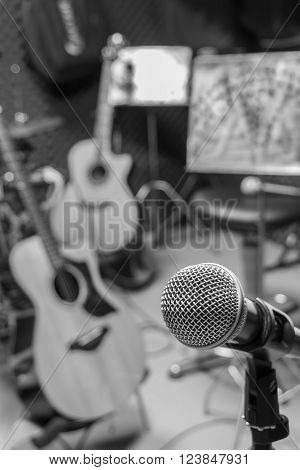 selective focus microphone and blur musical equipment guitar bass drum piano percussionist lyric background.