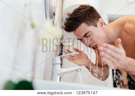 Man washing face in morning and practicing hygiene