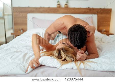 Happy couple in bedroom enjoying sensual foreplay