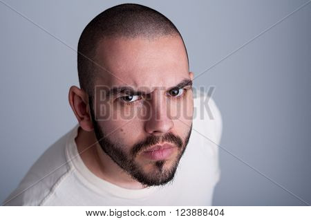 Young bearded man looking angry acting badboy or macho