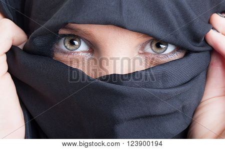 Close-up with beautiful islamic woman eyes and face covered by black burka