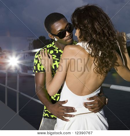 couple d'amoureux dans le port de nuit, afro homme embrasse femme caucasienne
