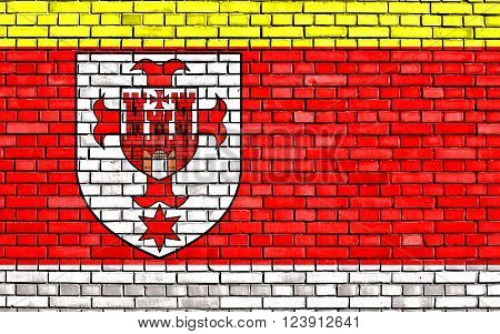 flag of Kluczbork County painted on brick wall
