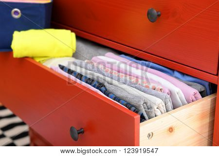 Neatly folded clothes in open drawer, close up