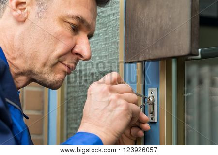 Mature Male Lockpicker Fixing Door Handle At Home