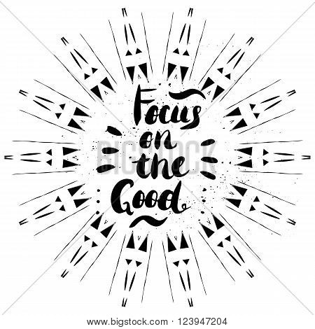 Focus on the good -  hand painted brush pen modern calligraphy with rough edges. Inspirational motivational quote isolated in sunbursting rays frame on the ink texture background.
