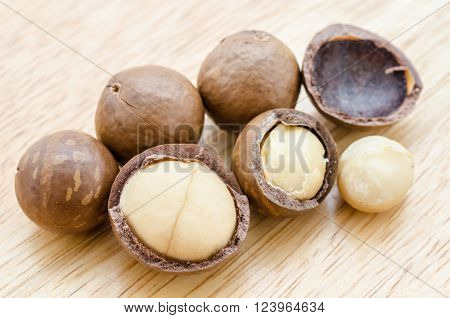 The brown Macadamia nut on wooden background