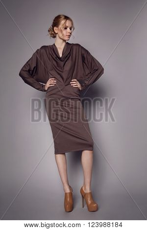Beautiful Woman in stylish silk Dress posing in studio