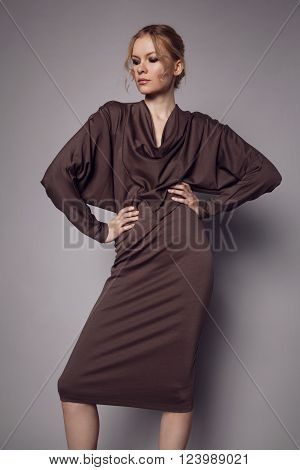 Beautiful Woman in stylish silk Dress posing in studio