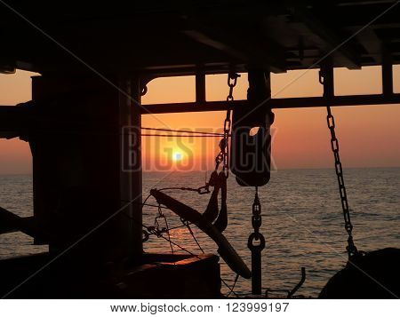 boat chains and anchor at sunset with sun