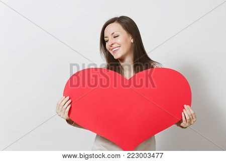 Beautiful Young Smiling Woman Holding Big Red Heart In Hands Isolated On White Background. Copy Spac