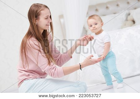 First step. happy mother and walking infant baby