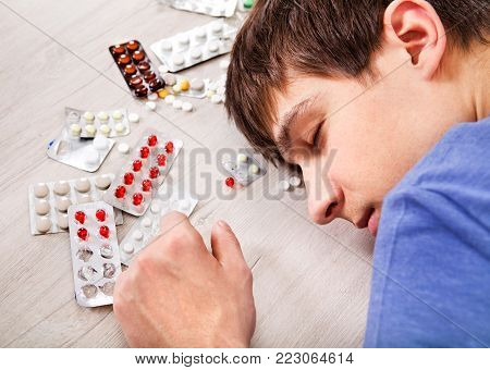 Young Man sleep with a Pills on the Table