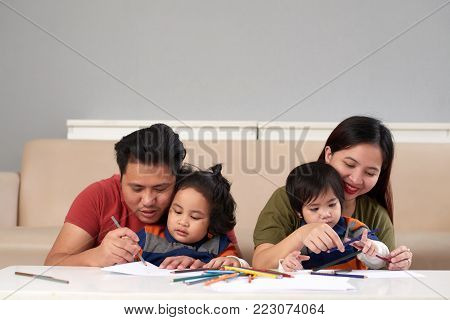 Parents and theis children drawing together at home