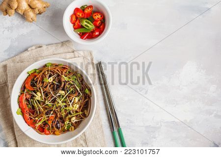 Healthy vegan buckwheat noodles with a mix of vegetables, sprouts and nut-soy sauce. Vegetarian padthai soba noodles in white bowl