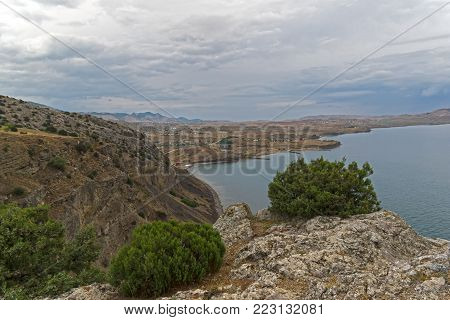 View from the top of Cape Alchak towards the bay of Kapsel. Overcast summer day. Surroundings of Sudak, Crimea.