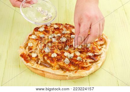 The process of making pie with apples and cheese DorBlu. Dessert pizza with apples and cheese.
