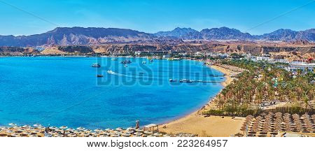 Sharm El Maya is one of the central districts of resort, that boasts scenic rocky landscape and beautiful beaches with palms and multiple sunshades, Sharm El Sheikh, Egypt.
