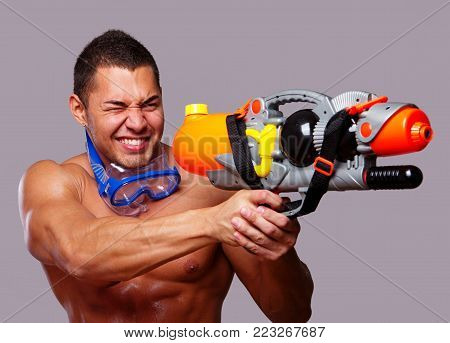 man playing with water guns in studio