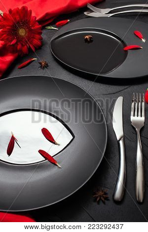Matte plate on black background with red accent color. Restaurant table layout for fancy dinner concept