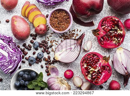 Vegetables and fruits with anthocyanin purple and pink: red cabbage, onion, pomegranate, blueberries, rice, apples, potatoes, garlic beans, radish for healthy nutrition. Top view. Color of the year violet