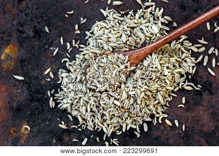 Fennel Seeds In A Wooden Spoon. Spice Over The Black Rusty Background